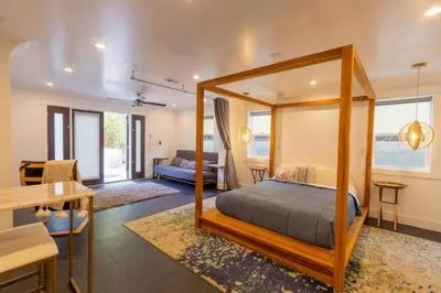 a bedroom with a canopy bed and a living room at Deluxe Master Studio Private Entrance and Patio in San Diego