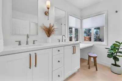 a white bathroom with two sinks and a potted plant at Stunning 3BR Capo Beach Home with Ocean Views in Dana Point
