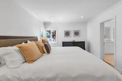 a white bedroom with a large bed with pillows at Stunning 3BR Capo Beach Home with Ocean Views in Dana Point