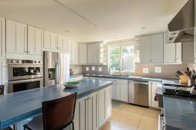 a kitchen with white cabinets and a blue counter top at San Diego Staycation Home with Hot Tub Ocean Views in Encinitas