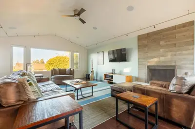 a living room with a couch and a fireplace at San Diego Staycation Home with Hot Tub Ocean Views in Encinitas