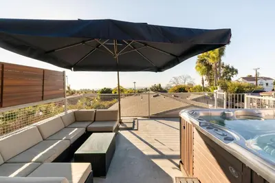 a patio with a hot tub and an umbrella at San Diego Staycation Home with Hot Tub Ocean Views in Encinitas