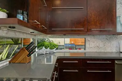 a kitchen with wooden cabinets and a counter top at Sunset Cliffs Dream Home Ocean View Family Getaway in San Diego
