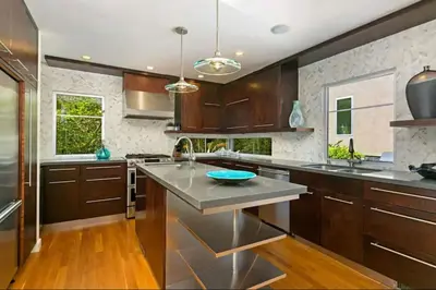a kitchen with wooden cabinets and stainless steel appliances at Sunset Cliffs Dream Home Ocean View Family Getaway in San Diego