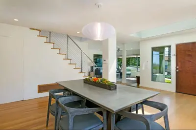 a dining room with a table and chairs and a staircase at Sunset Cliffs Dream Home Ocean View Family Getaway in San Diego
