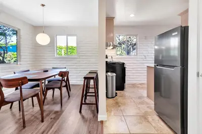 a kitchen and dining room with a table and a refrigerator at Comfortable Carlsbad 2BR Beach Home Walk to Beach in Carlsbad