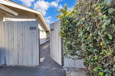 a white fence with a hedge next to a house at Comfortable Carlsbad 2BR Beach Home Walk to Beach in Carlsbad