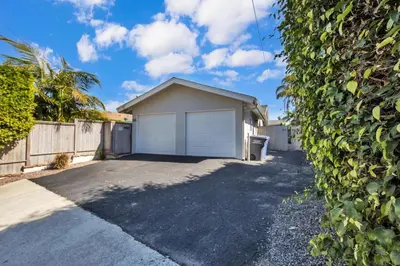 a house with a garage in front of a driveway at Comfortable Carlsbad 2BR Beach Home Walk to Beach in Carlsbad