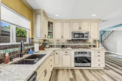 a kitchen with white cabinets and a sink at Stunning 4BR Laguna Hills Oasis with Private Pool in Laguna Hills