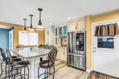 a kitchen with a table and chairs and a refrigerator at Stunning 4BR Laguna Hills Oasis with Private Pool in Laguna Hills