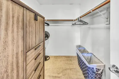 a walk in closet with a wooden cabinet at Stunning 4BR Laguna Hills Oasis with Private Pool in Laguna Hills