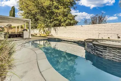 a swimming pool in a backyard with a brick wall at Stunning 4BR Laguna Hills Oasis with Private Pool in Laguna Hills