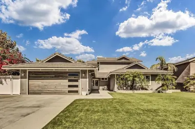 a house with a garage and grass at Stunning 4BR Laguna Hills Oasis with Private Pool in Laguna Hills