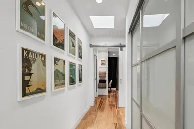 a hallway with white walls and paintings on the walls at Encinitas Beach Family Retreat with Hot Tub in Encinitas