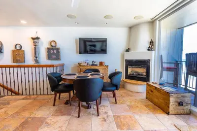 a dining room with a table and chairs and a fireplace at Oceanfront Condo on Sand, Walk to Carlsbad Village in Carlsbad
