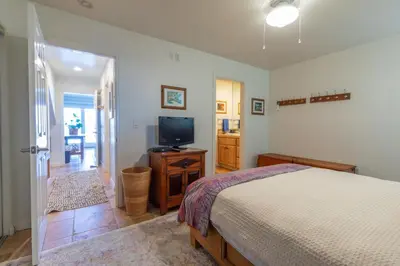 a bedroom with a bed and a flat screen tv at Oceanfront Condo on Sand, Walk to Carlsbad Village in Carlsbad