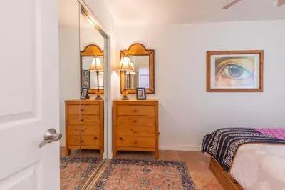 a bedroom with a bed and a dresser and a mirror at Oceanfront Condo on Sand, Walk to Carlsbad Village in Carlsbad