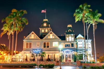a large white house with palm trees at night at Oceanfront Condo on Sand, Walk to Carlsbad Village in Carlsbad