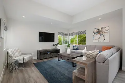 a living room with a couch and a tv at Chic Upstairs Condo Steps from Strands Beach in Dana Point