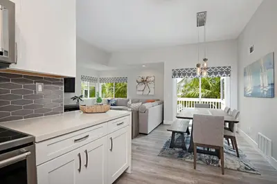 a kitchen and living room with a table and a couch at Chic Upstairs Condo Steps from Strands Beach in Dana Point