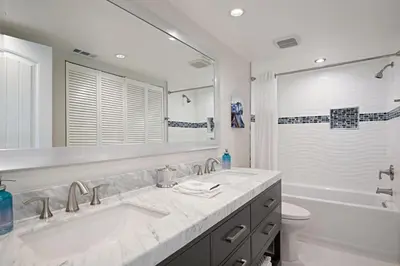 a bathroom with two sinks and a tub and a toilet at Chic Upstairs Condo Steps from Strands Beach in Dana Point