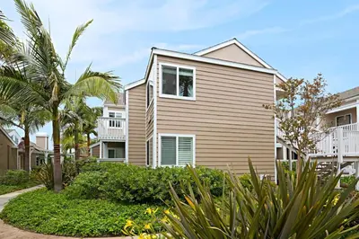 a house with a garden and palm trees at Chic Upstairs Condo Steps from Strands Beach in Dana Point