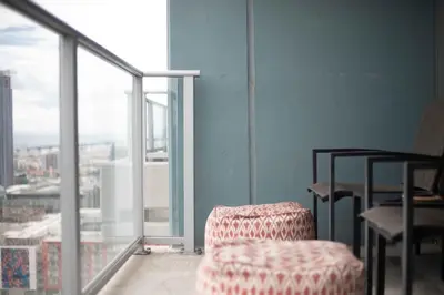 a living room with a chair and a balcony at Modern Downtown SD Apartment Stunning City Views in San Diego
