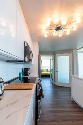 a kitchen with a ceiling fan and a kitchen counter at Modern Downtown SD Apartment Stunning City Views in San Diego