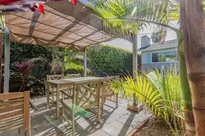 a patio with a table and chairs under a umbrella at Staycation Beach Family Home Great Indoor Outdoor in Carlsbad