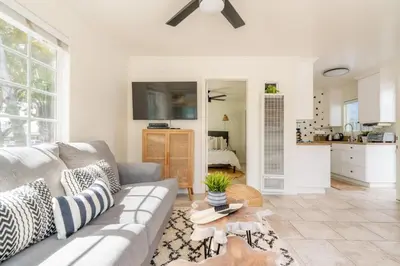 a living room with a couch and a kitchen at Pacific Beach Cottage 1 Walk to the Beach and Bay in San Diego