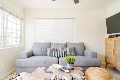 a living room with a couch and a table at Pacific Beach Cottage 1 Walk to the Beach and Bay in San Diego