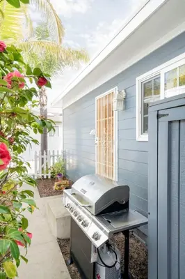 a grill on a patio next to a house at Pacific Beach Cottage 1 Walk to the Beach and Bay in San Diego