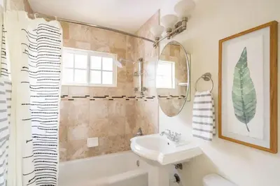 a bathroom with a sink and a mirror and a tub at Pacific Beach Cottage 3 Walk to the Beach and Bay in San Diego