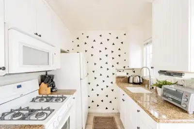 a white kitchen with black stars on the wall at Pacific Beach Cottage 3 Walk to the Beach and Bay in San Diego