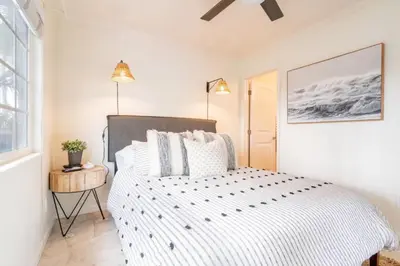 a bedroom with a bed and a window and a ceiling fan at Pacific Beach Cottage 2 Walk to the Beach and Bay in San Diego