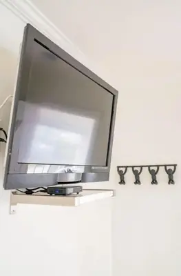 a flat screen tv sitting on top of a white wall at Pacific Beach Cottage 2 Walk to the Beach and Bay in San Diego