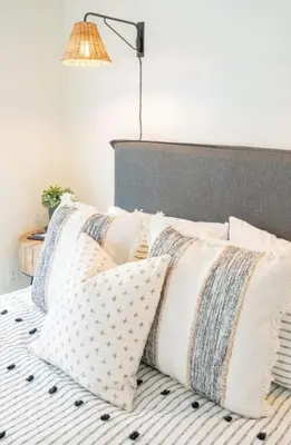 a pile of pillows on a bed under a lamp at Pacific Beach Cottage 2 Walk to the Beach and Bay in San Diego