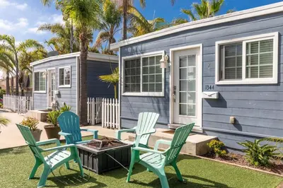 a blue tiny house with chairs and a fire pit at Pacific Beach Cottage 2 Walk to the Beach and Bay in San Diego