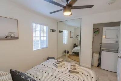 a living room with a bed and a ceiling fan at Pacific Beach Cottage 4 Walk to the Beach and Bay in San Diego