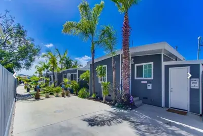 a house with palm trees in front of it at Pacific Beach Cottage 4 Walk to the Beach and Bay in San Diego