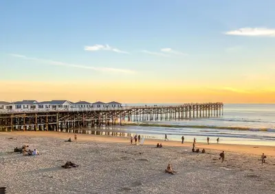 a group of people on the beach near a pier at Pacific Beach Cottage 4 Walk to the Beach and Bay in San Diego