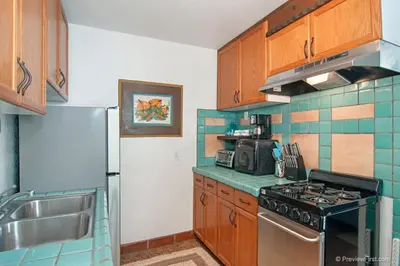 a kitchen with a stove and a refrigerator at Cute Old Town Cottage near Downtown Beaches in San Diego