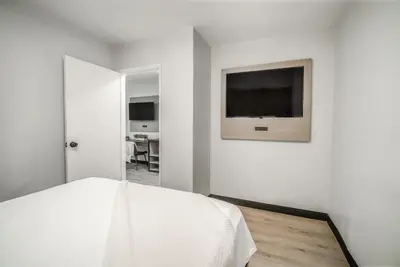a bedroom with a bed and a television on the wall at ERTH INN by AGA- San Ysidro in San Diego