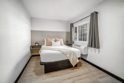 a bedroom with a large bed and a window at ERTH INN by AGA- San Ysidro in San Diego