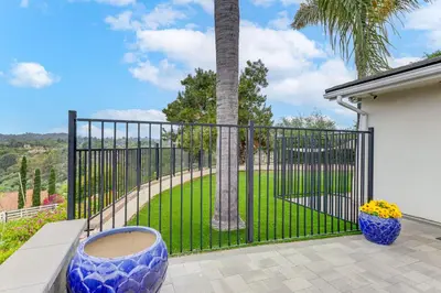 a gate with two blue vases and a palm tree at 2 Mi to Lake Poway Mtn-View Escape with Patio! in Poway
