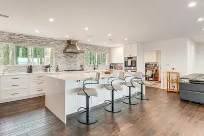 a kitchen with white cabinets and bar stools at 2 Mi to Lake Poway Mtn-View Escape with Patio! in Poway