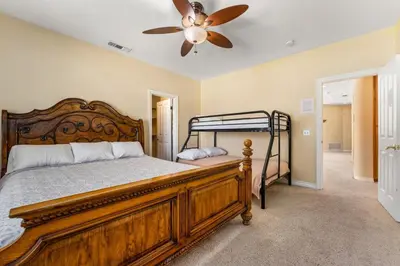 a bedroom with a wooden bed and a ceiling fan at Lakeside Mansion Waterfront 34 beds Boat ramp in Lake Elsinore