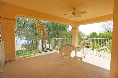 a porch with two chairs and a ceiling fan at Lakeside Mansion Waterfront 34 beds Boat ramp in Lake Elsinore