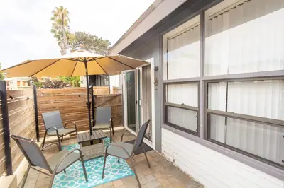 a patio with a table and chairs and an umbrella at Ocean Beach Bungalow Separate Entry in San Diego
