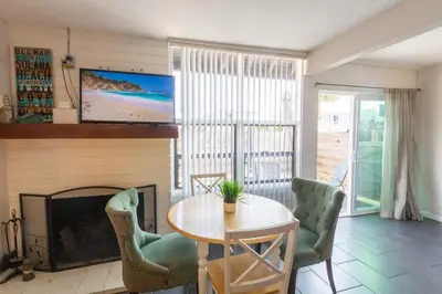 a living room with a fireplace and a table and chairs at Ocean Beach Bungalow Separate Entry in San Diego